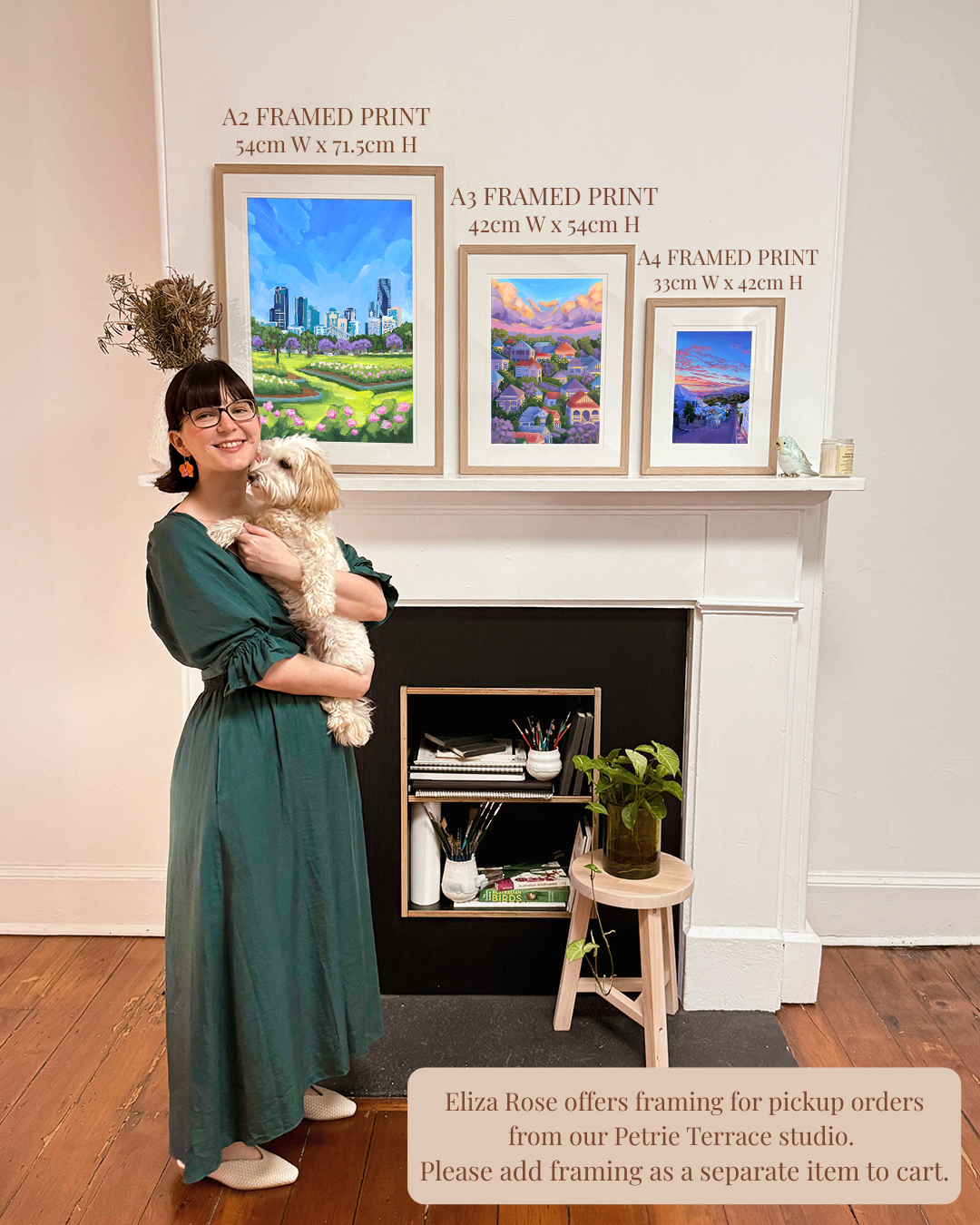Woman holding a dog in front of framed prints on a fireplace mantle.